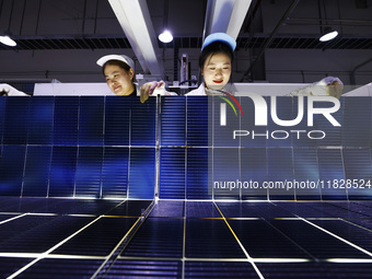 Workers produce export photovoltaic modules in a new energy 5G intelligent workshop in Suqian, China, on December 2, 2024. (