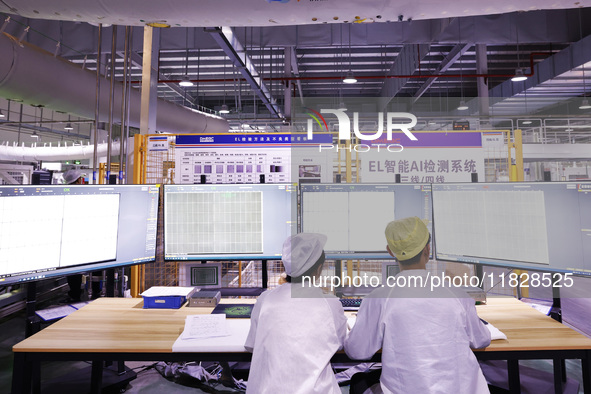 Workers produce export photovoltaic modules in a new energy 5G intelligent workshop in Suqian, China, on December 2, 2024. 