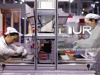 Workers produce export photovoltaic modules in a new energy 5G intelligent workshop in Suqian, China, on December 2, 2024. (