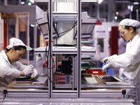 Workers produce export photovoltaic modules in a new energy 5G intelligent workshop in Suqian, China, on December 2, 2024. (