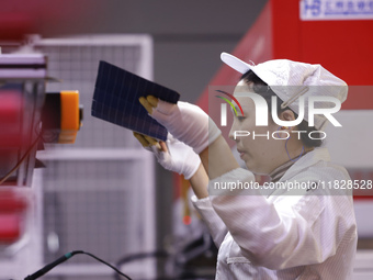 Workers produce export photovoltaic modules in a new energy 5G intelligent workshop in Suqian, China, on December 2, 2024. (