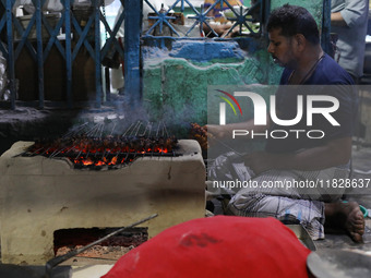 A street vendor grills chicken kebabs at his roadside stall in Kolkata, India, on December 02, 2024. Consumer price inflation in India climb...