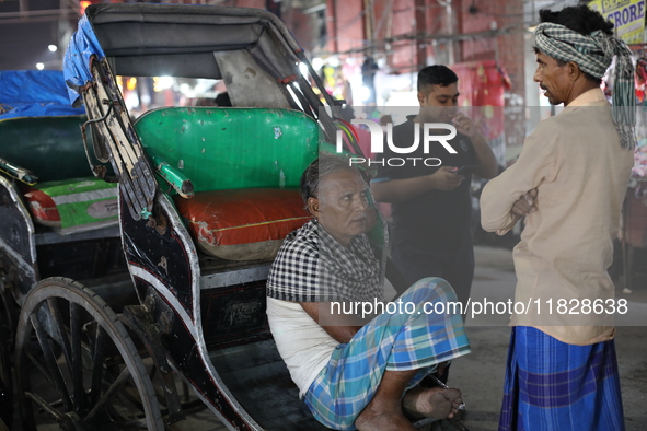 Hand-pulled rickshaw pullers wait for passengers at a roadside stall in Kolkata, India, on December 02, 2024. 