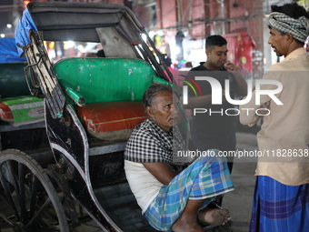 Hand-pulled rickshaw pullers wait for passengers at a roadside stall in Kolkata, India, on December 02, 2024. (