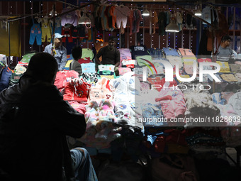 Vendors wait for customers at their roadside cloth stalls in Kolkata, India, on December 02, 2024. (