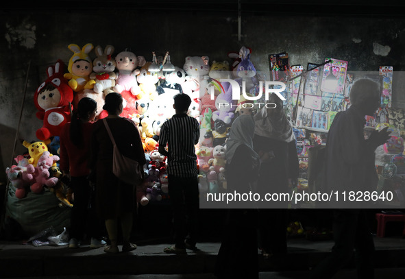 People shop for soft toys at a roadside stall in Kolkata, India, on December 02, 2024.  