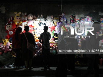 People shop for soft toys at a roadside stall in Kolkata, India, on December 02, 2024.  (