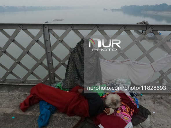 An elderly homeless man takes a rest on Vivekananda Bridge over the River Ganga amid rising air pollution levels in Kolkata, India, on Decem...