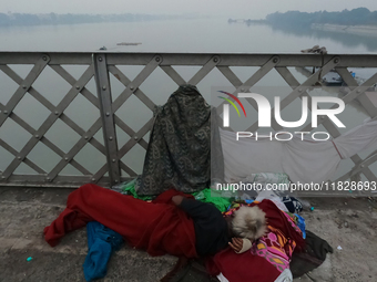 An elderly homeless man takes a rest on Vivekananda Bridge over the River Ganga amid rising air pollution levels in Kolkata, India, on Decem...