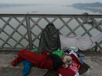 An elderly homeless man takes a rest on Vivekananda Bridge over the River Ganga amid rising air pollution levels in Kolkata, India, on Decem...