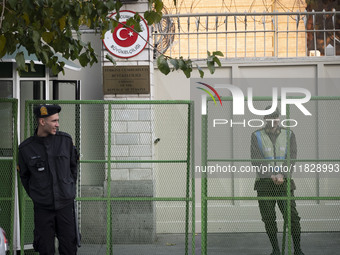 Iranian policemen stand guard outside the Turkish embassy during a protest against Turkish President Recep Tayyip Erdogan and his diplomacy...