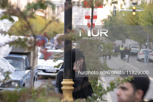 A veiled Iranian woman speaks on her cellphone during a protest against Turkish President Recep Tayyip Erdogan and his diplomacy regarding r...