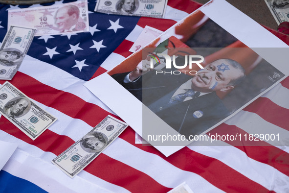 Copies of the U.S. Dollar, Turkish Lira banknotes, and an anti-Turkish President poster are placed by Iranian protesters on the U.S. flag du...