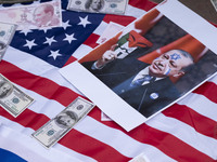 Copies of the U.S. Dollar, Turkish Lira banknotes, and an anti-Turkish President poster are placed by Iranian protesters on the U.S. flag du...