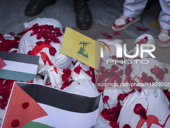 Iranian protesters stand behind packages wrapped in shrouds symbolizing the bodies of people of Syria during a protest against Turkish Presi...