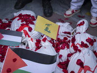 Iranian protesters stand behind packages wrapped in shrouds symbolizing the bodies of people of Syria during a protest against Turkish Presi...