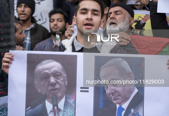 An Iranian protester holds a poster featuring portraits of the Turkish President and Israeli Prime Minister Benjamin Netanyahu during a prot...