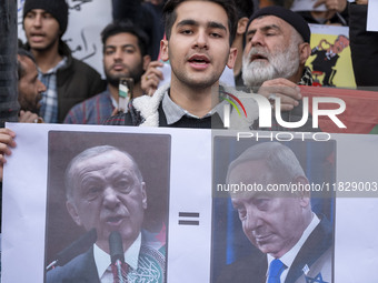 An Iranian protester holds a poster featuring portraits of the Turkish President and Israeli Prime Minister Benjamin Netanyahu during a prot...