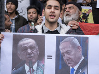 An Iranian protester holds a poster featuring portraits of the Turkish President and Israeli Prime Minister Benjamin Netanyahu during a prot...