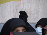 A veiled Iranian protester waves a flag of Lebanon's Hezbollah while taking part in a protest against Turkish President Recep Tayyip Erdogan...