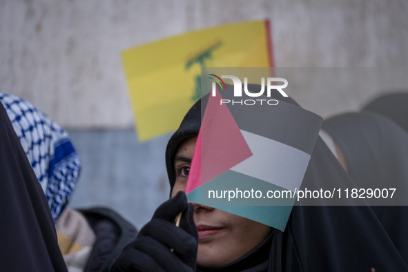 A veiled Iranian protester waves a Palestinian flag while participating in a protest against Turkish President Recep Tayyip Erdogan and his...