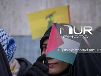 A veiled Iranian protester waves a Palestinian flag while participating in a protest against Turkish President Recep Tayyip Erdogan and his...