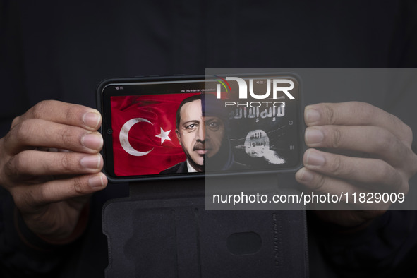 An Iranian protester holds a cellphone displaying an anti-Turkish President poster while participating in a protest against Turkish Presiden...