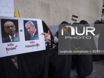 A veiled Iranian protester holds a poster featuring portraits of Turkish President Recep Tayyip Erdogan and Israeli Prime Minister Benjamin...