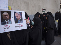 A veiled Iranian protester holds a poster featuring portraits of Turkish President Recep Tayyip Erdogan and Israeli Prime Minister Benjamin...