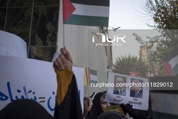 A veiled Iranian protester holds a poster featuring portraits of Turkish President Recep Tayyip Erdogan and Israeli Prime Minister Benjamin...