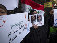 Veiled Iranian protesters hold an anti-Turkish placard and a poster featuring portraits of Turkish President Recep Tayyip Erdogan and Israel...