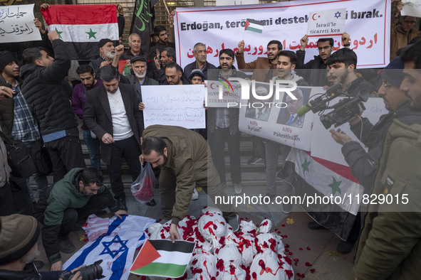 An Iranian protester places a Palestinian flag on packages wrapped in shrouds symbolizing the bodies of people of Syria during a protest aga...