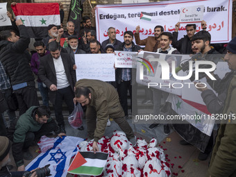 An Iranian protester places a Palestinian flag on packages wrapped in shrouds symbolizing the bodies of people of Syria during a protest aga...