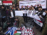 An Iranian protester places a Palestinian flag on packages wrapped in shrouds symbolizing the bodies of people of Syria during a protest aga...