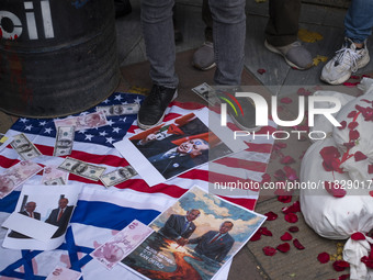 An Iranian protester stands on the U.S. flag covered with copies of U.S. Dollar and Turkish Lira banknotes, and posters featuring portraits...