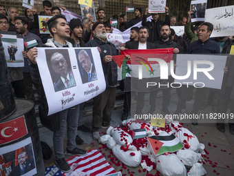 Iranian protesters hold a Syrian flag and an anti-Turkish President placard featuring portraits of the Turkish President and Israeli Prime M...