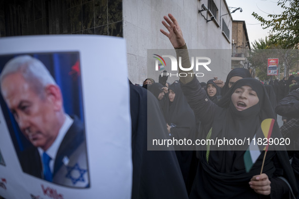 A veiled Iranian protester shouts anti-Turkish President slogans while standing next to a portrait of Israeli Prime Minister Benjamin Netany...