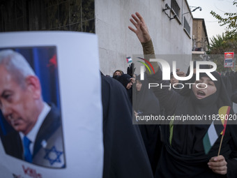 A veiled Iranian protester shouts anti-Turkish President slogans while standing next to a portrait of Israeli Prime Minister Benjamin Netany...