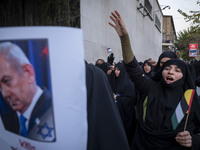 A veiled Iranian protester shouts anti-Turkish President slogans while standing next to a portrait of Israeli Prime Minister Benjamin Netany...