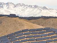 Workers of Huaneng Yili Xexin Photovoltaic Power Plant inspect equipment on a barren slope in Yili, Xinjiang province, China, on November 30...