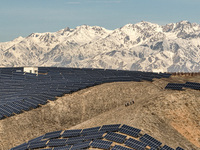 Workers of Huaneng Yili Xexin Photovoltaic Power Plant inspect equipment on a barren slope in Yili, Xinjiang province, China, on November 30...