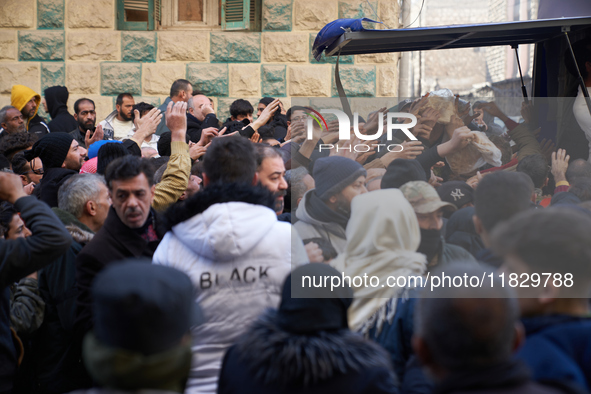 People crowd to get free bread in the Bustan Al-Qasr neighborhood in Aleppo, on December 1, 2024. 