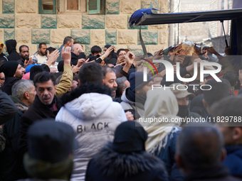 People crowd to get free bread in the Bustan Al-Qasr neighborhood in Aleppo, on December 1, 2024. (