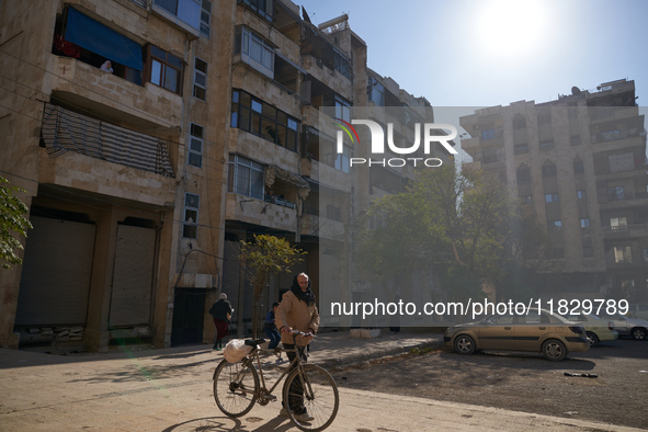 An old man drags his bicycle in the Bustan Al-Qasr neighborhood in Aleppo, Syria, on December 1, 2024. 