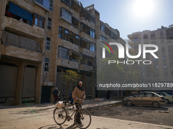 An old man drags his bicycle in the Bustan Al-Qasr neighborhood in Aleppo, Syria, on December 1, 2024. (