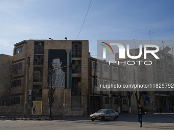 A man walks past a government building with a picture of Syrian President Bashar al-Assad in Aleppo, Syria, on December 1, 2024. (