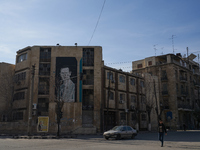 A man walks past a government building with a picture of Syrian President Bashar al-Assad in Aleppo, Syria, on December 1, 2024. (