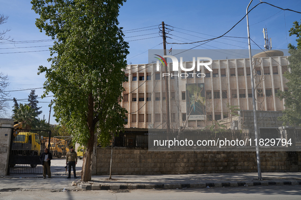 A Syrian opposition fighter stands guard at a government building in Aleppo, Syria, on December 1, 2024 