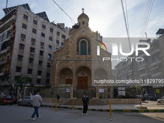 Residents walk near a church in Aleppo, Syria, on December 1, 2024, after the armed opposition takes control of the city. (