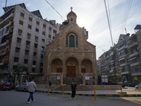 Residents walk near a church in Aleppo, Syria, on December 1, 2024, after the armed opposition takes control of the city. (